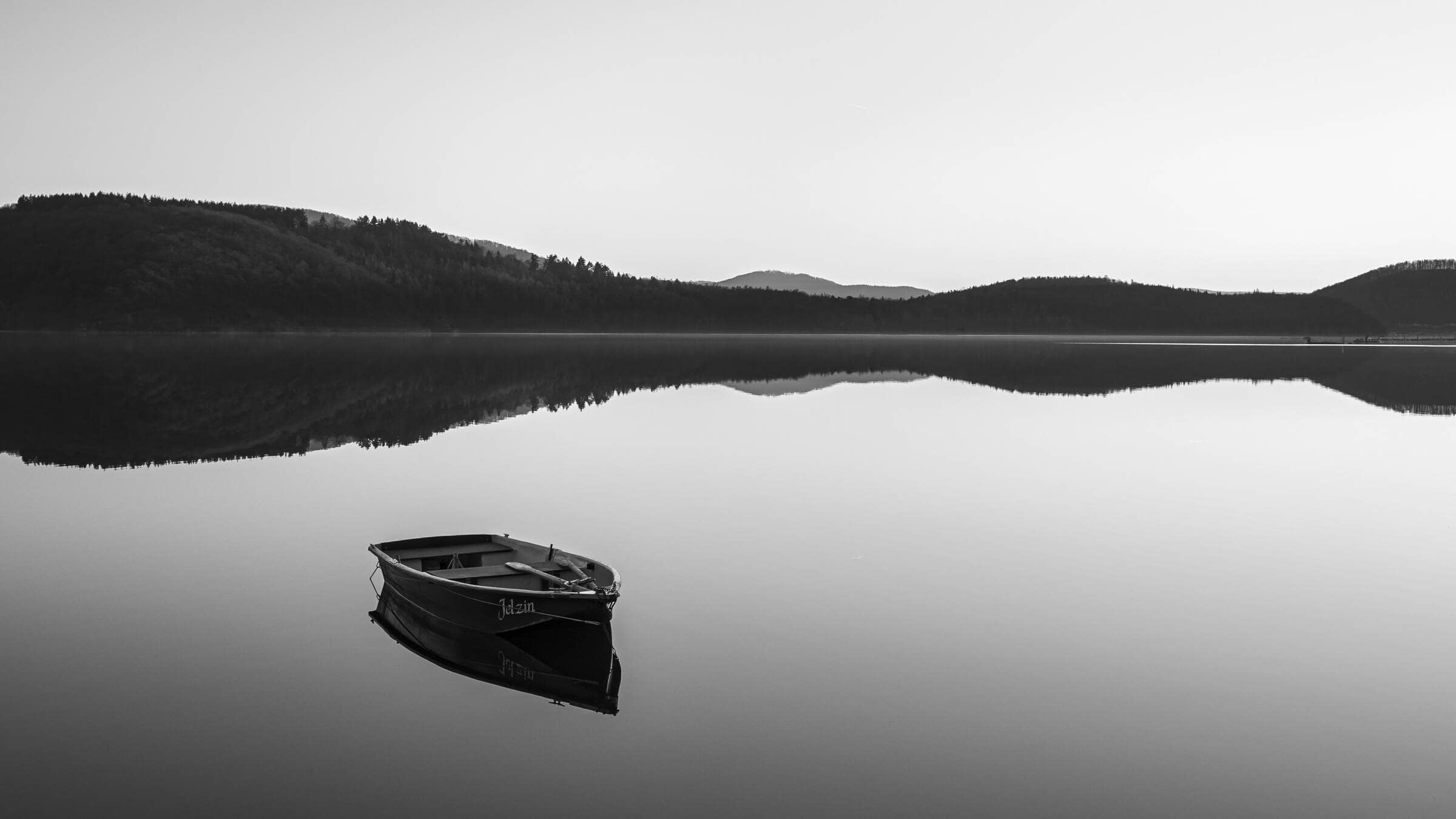 boat on calm lake near mountains photo